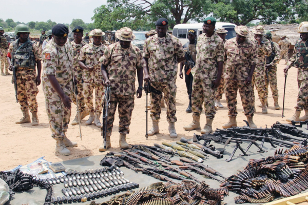 Military commanders inspect arms and ammunitions recovered from Boko Haram jihadists on display at the headquarters of the 120th Battalion in Gonirijpg